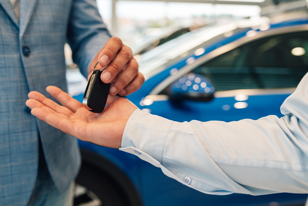 close-up-of-key-exchange-signifying-a-new-car-purc-2025-04-03-20-41-53-utc (1)